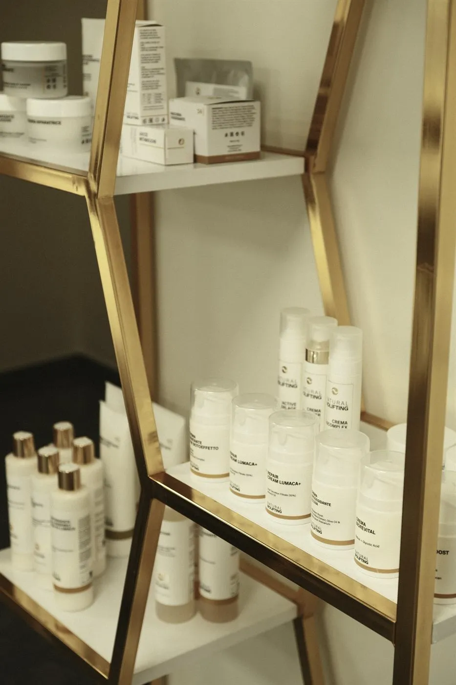 Кремове и серуми NaturalBioLifting на златен рафт в студиото: Repair Cream Lumaca+, Crema Biorevital и Crema Antiossidante.